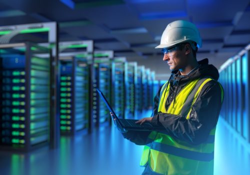 Man,Engineer,Inside,Data,Center.,Server,Racks,Behind,Guy,With